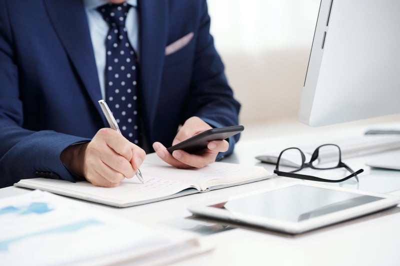 cropped-business-man-making-notes-from-his-smartphone-calendar-to-the-organizer